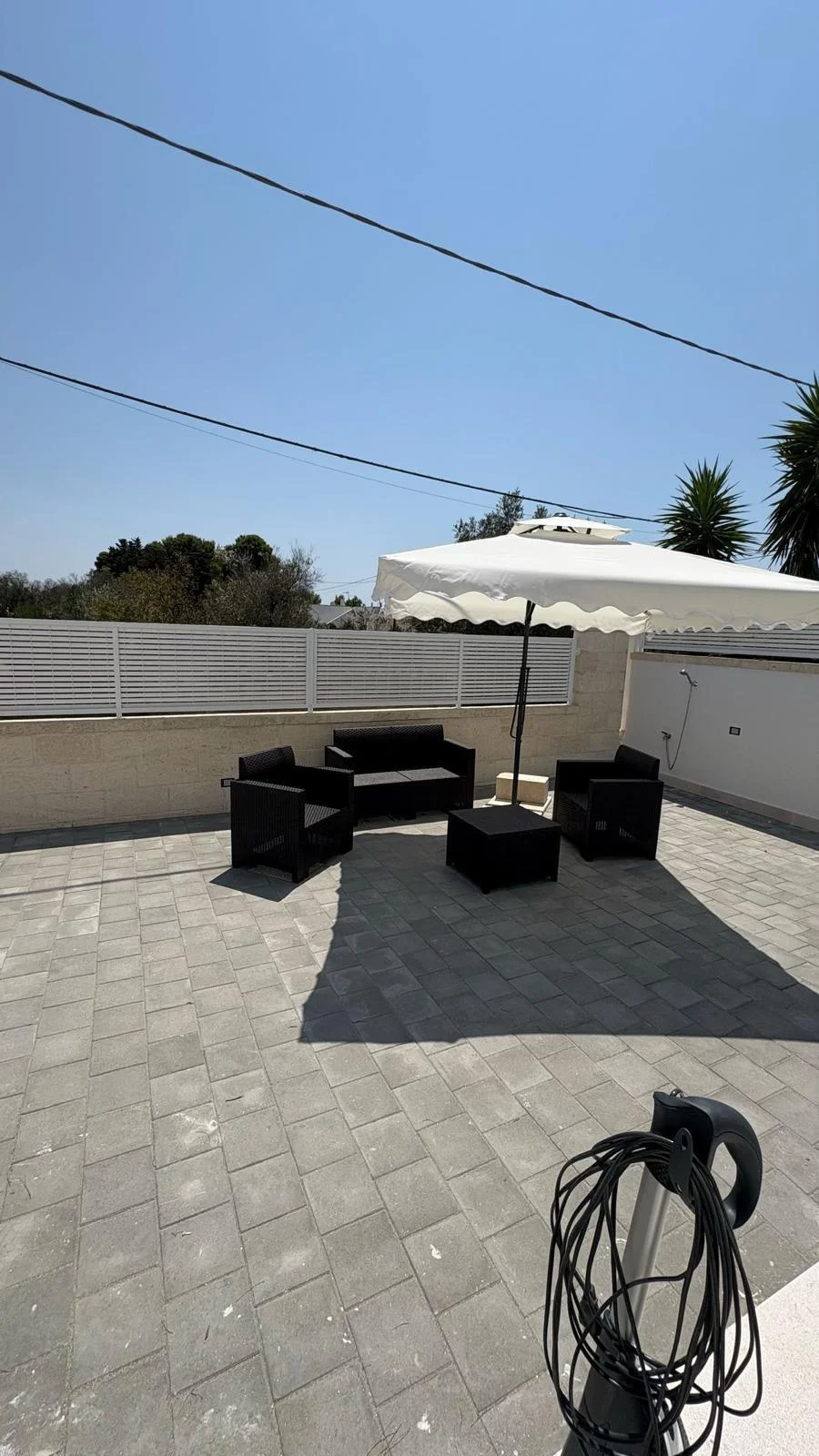 Angolo relax nel giardino con ombrellone aperto e sedute